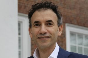 Tamer Zaki stands in front of a brick building